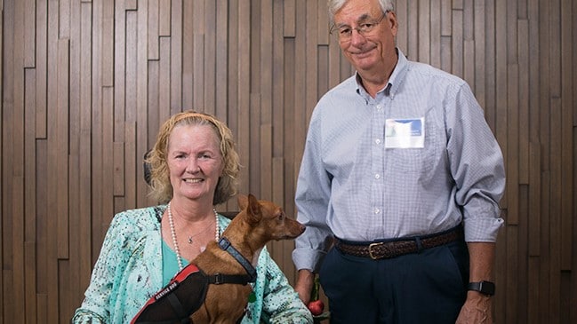 Caregiver with patient with service dog sitting on wheel chair