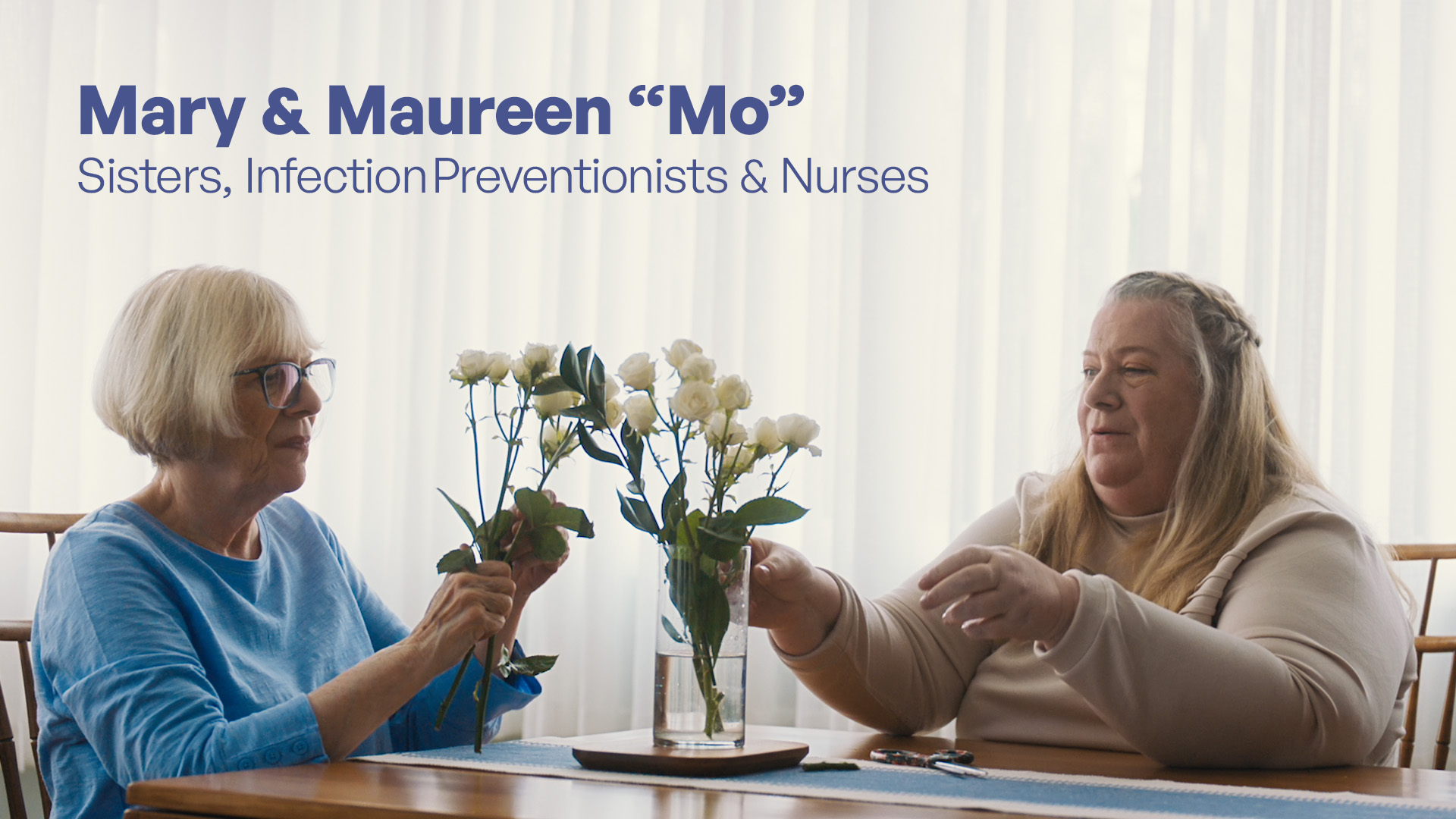 Mary & Mo Lansing are sisters, infection preventionists, & nurses. Mo & Mary are sitting at a table arranging flowers.