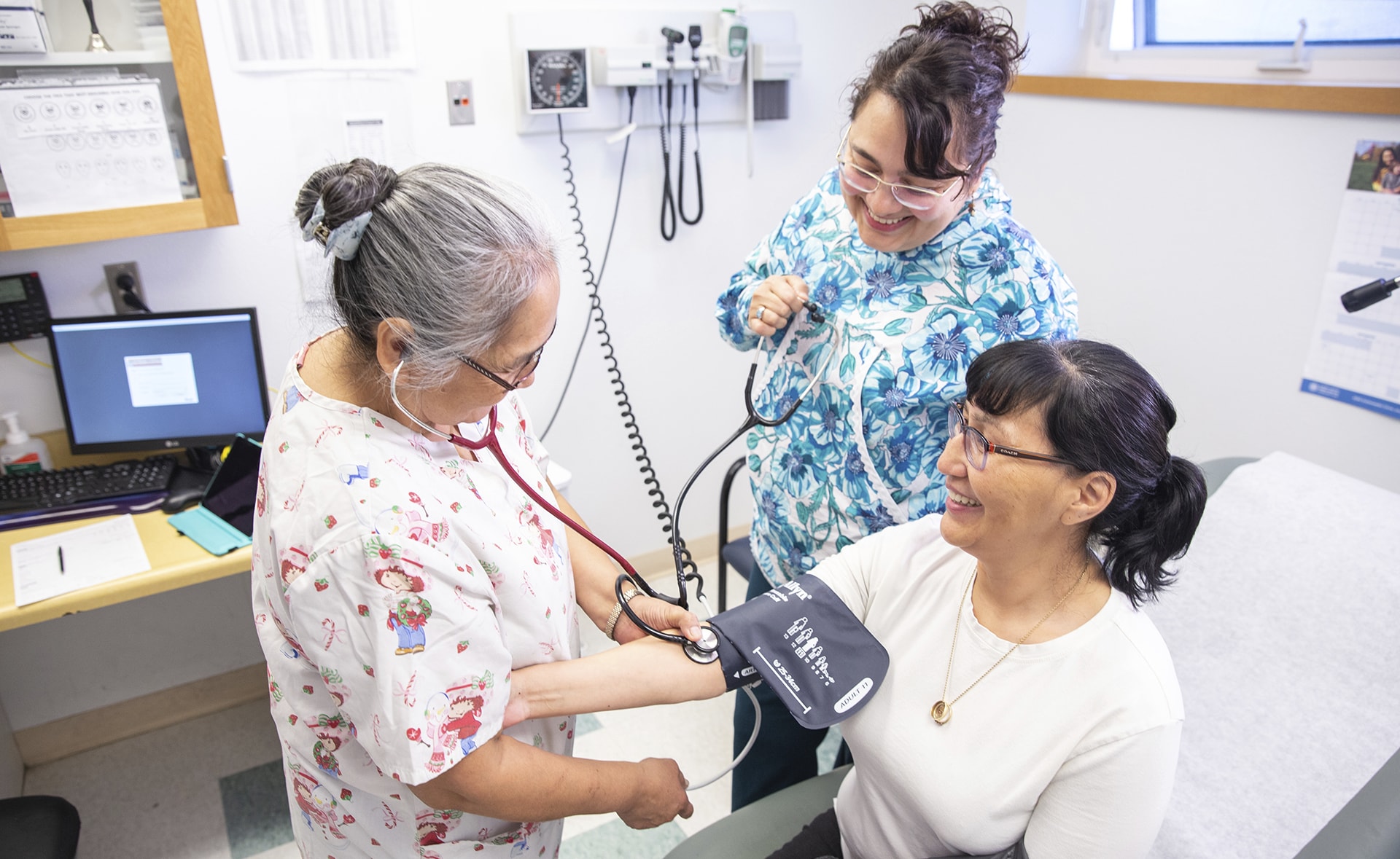 Two medical workers checking a patient's blood pressure with blood pressure arm cuff.
