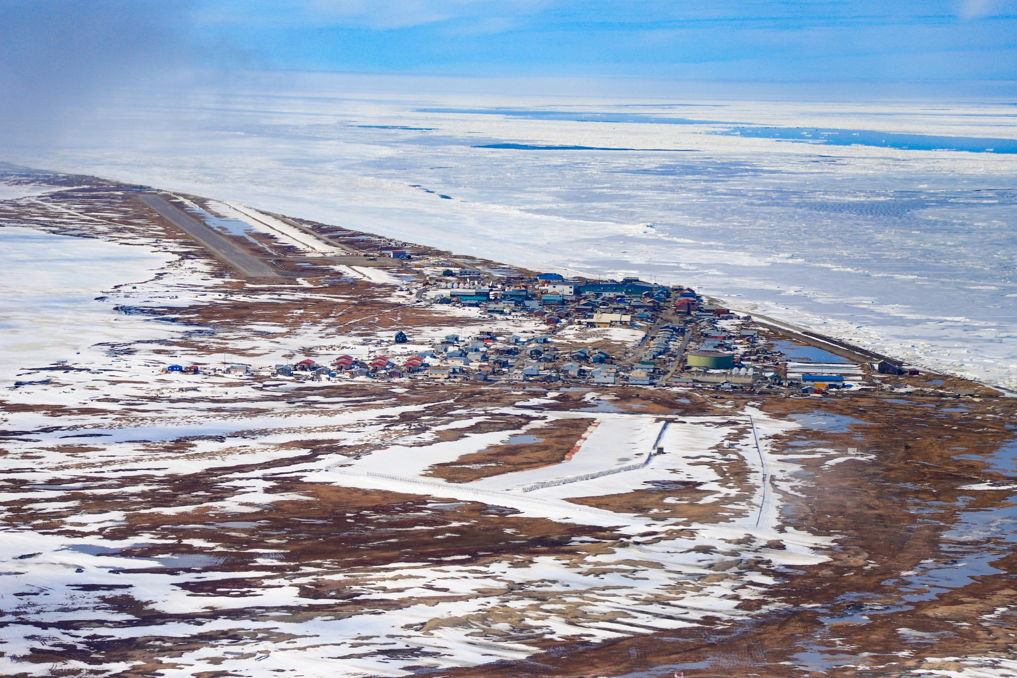 Aerial view of a town with patches of snow on the ground.