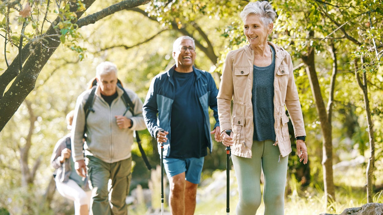 A group of four older adults hiking in nature together