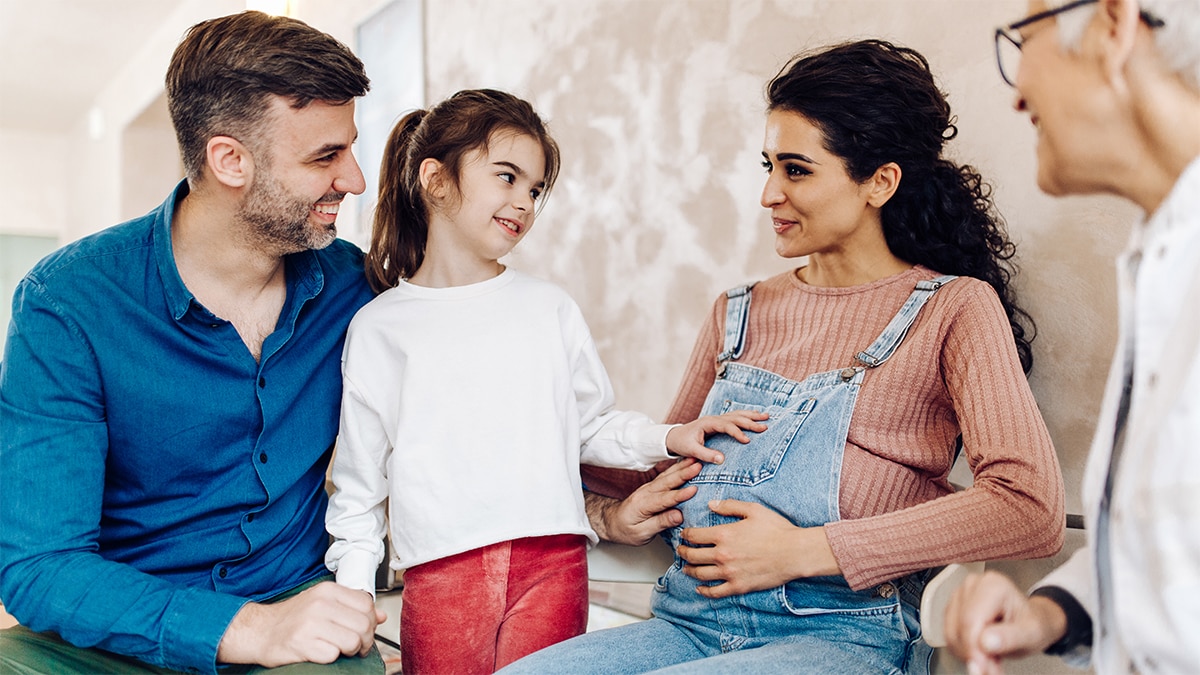 Pregnant mom with family talking to doctor