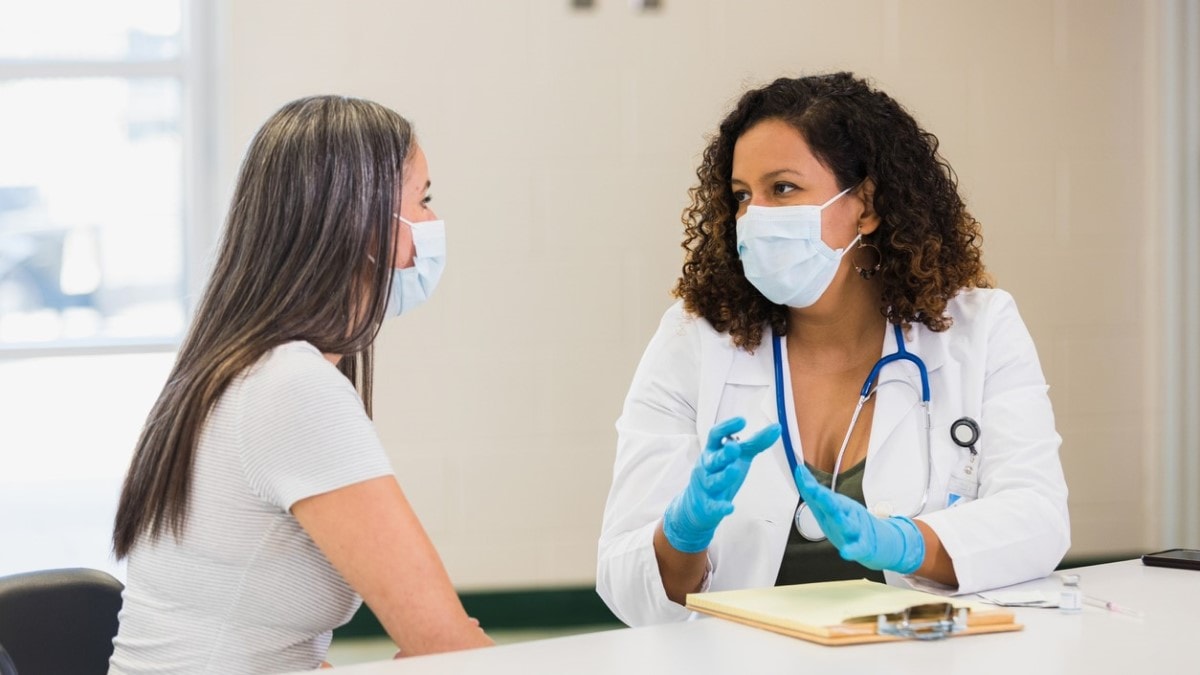 a concerned young female patient talking with a nurse