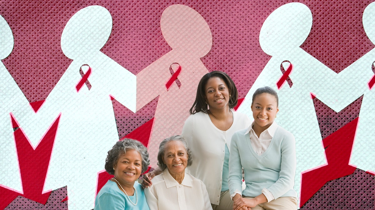Three generations of women standing in front of a backdrop of paper cut outs of human figures decorated with the breast cancer ribbon symbol.
