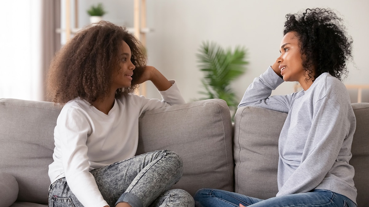 Dos mujeres sentadas en un sofá hablando