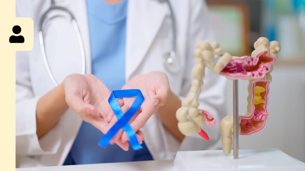 A doctor with a ribbon around her hands and the colon replica.