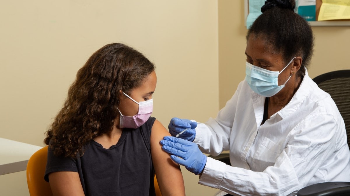 Foto de una médica dándole la vacuna contra el VPH a una niña