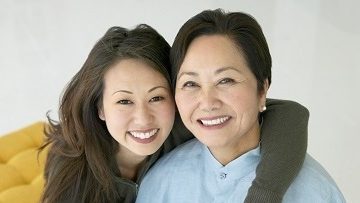 Female caregiver with her arm around older woman