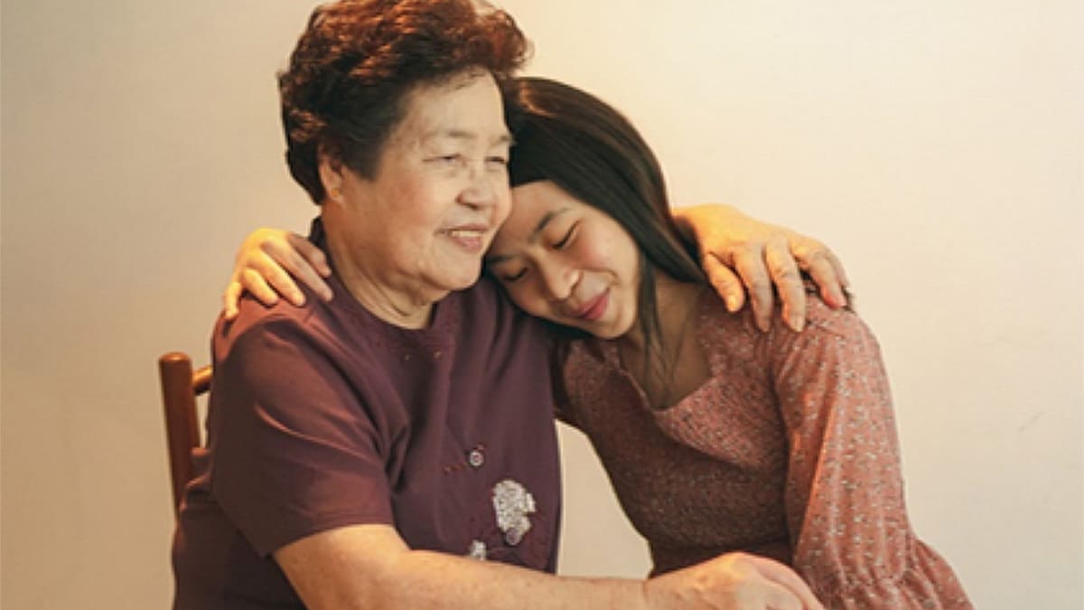 Asian mother and daughter hugging.