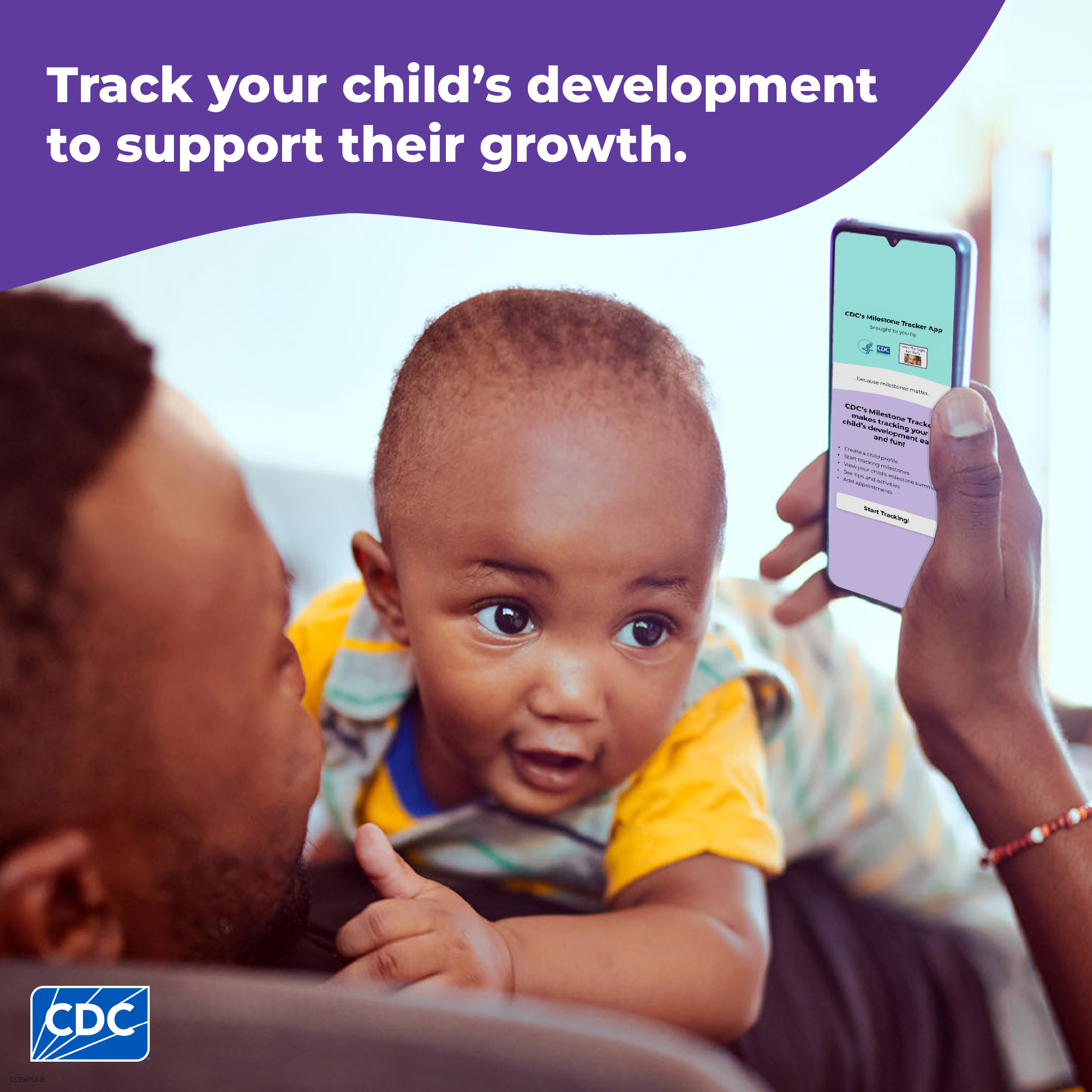 A dad holds infant while looking at milestone tracker app on smartphone.