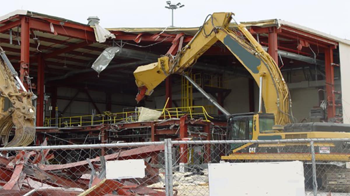 A material handler taking apart the metal structure of a chemical agent destruction building.