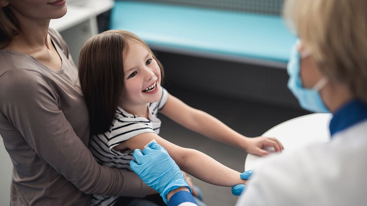 Vaccinated child smiling with doctor