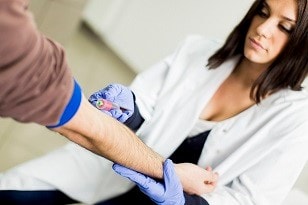 Man getting his blood drawn by a nurse for a cholesterol screening test.