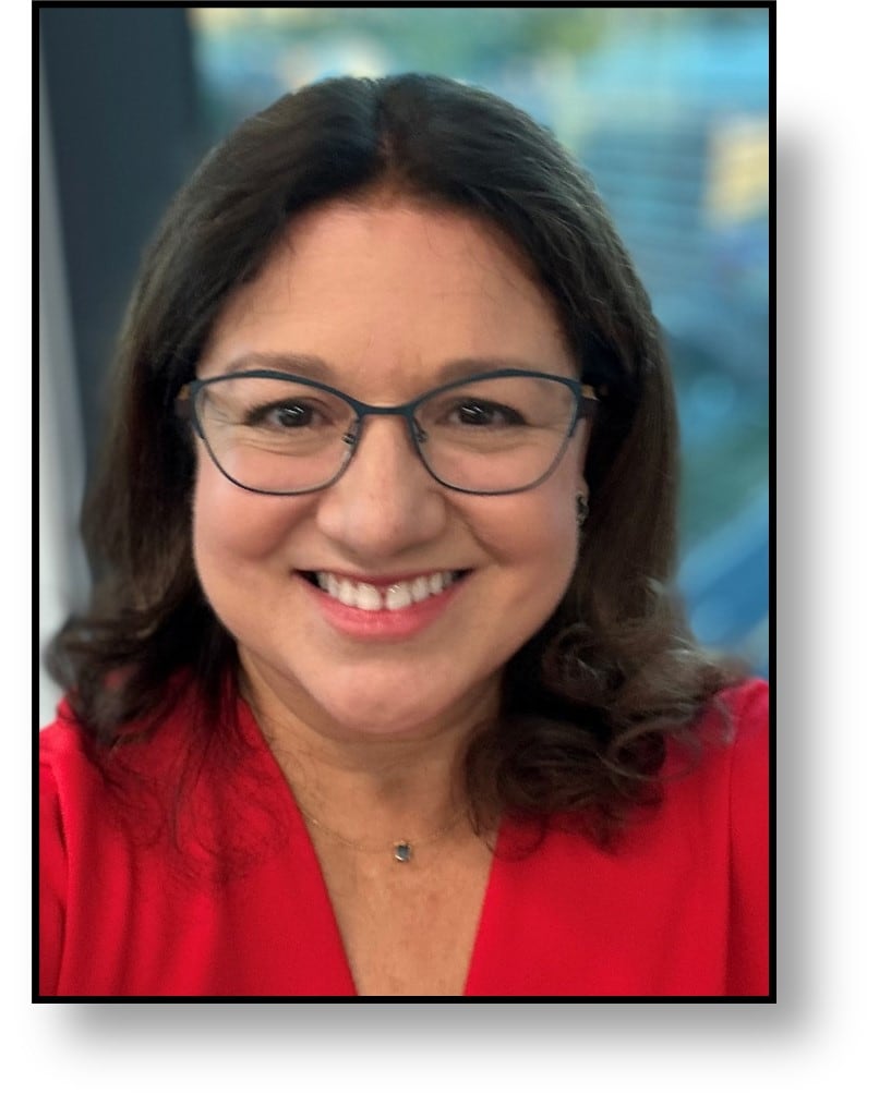 Profile picture of Olga M. Cerón, MD, FAAO. Dark brown, shoulder length hair wearing a red shirt and glasses.