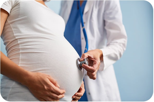 pregnant woman examined by doctor