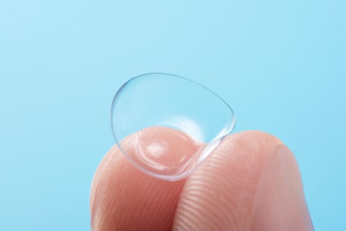 Contact lens held by two fingers