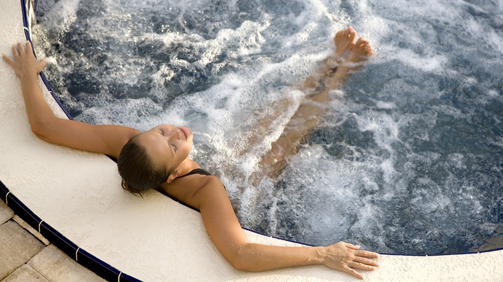 A woman relaxing in an outdoor hot tub
