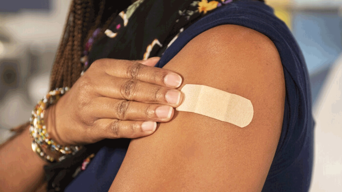 Picture of a young woman's upper arm with Band-Aid after receiving a COVID-19 vaccine.