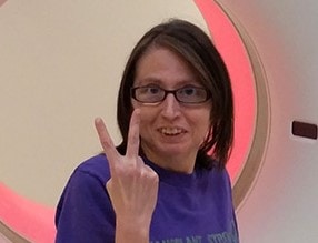 Woman making a peace sign before getting an MRI