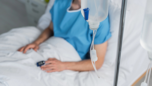Patient In Bed with Blue top and IV connected