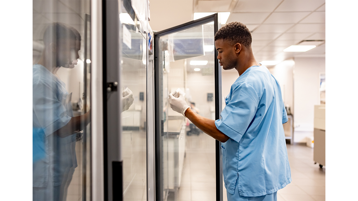 A healthcare provider removing vial from a laboratory refrigerator.