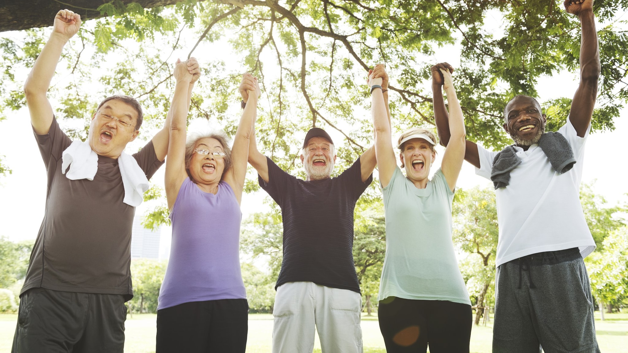 Group of happy older adults with their fists in the air to show success