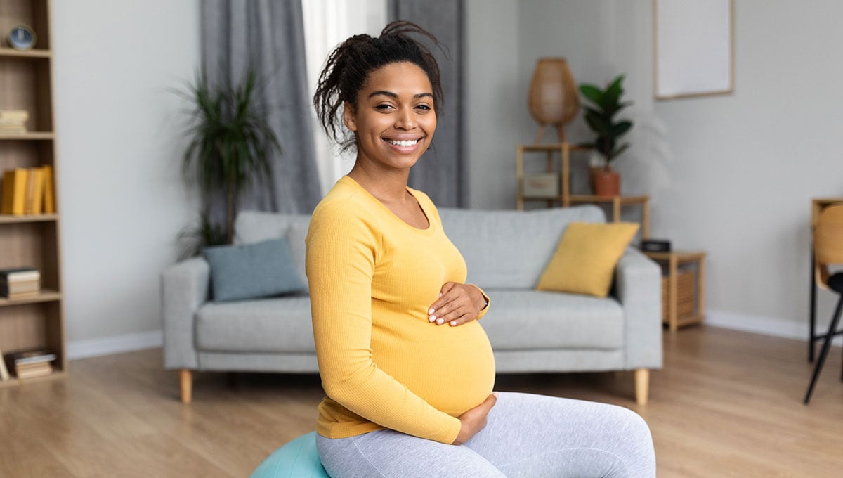 smiling pregnant person sitting down