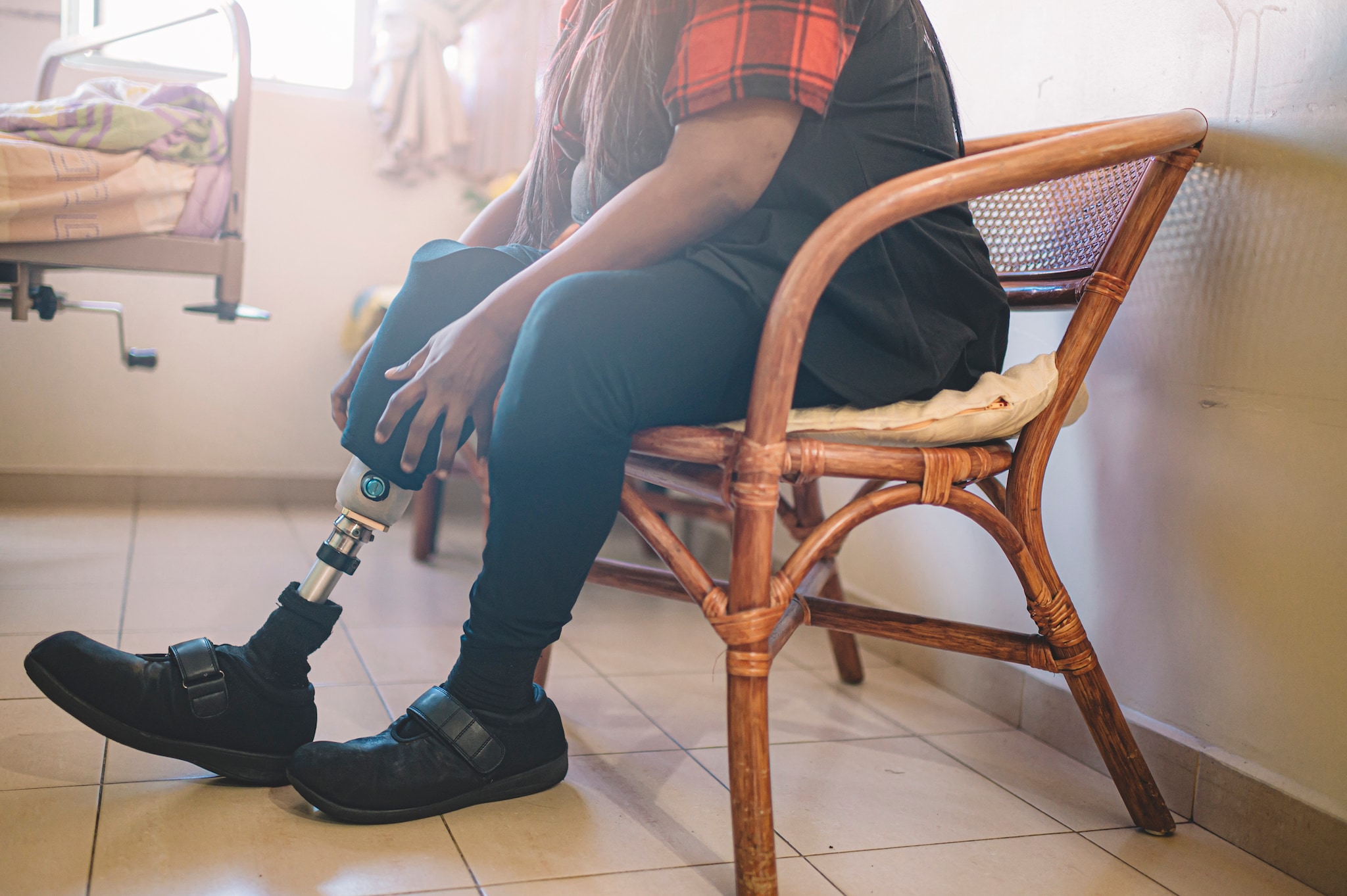 Persona con una pierna prostética ajustando la extremidad artificial.