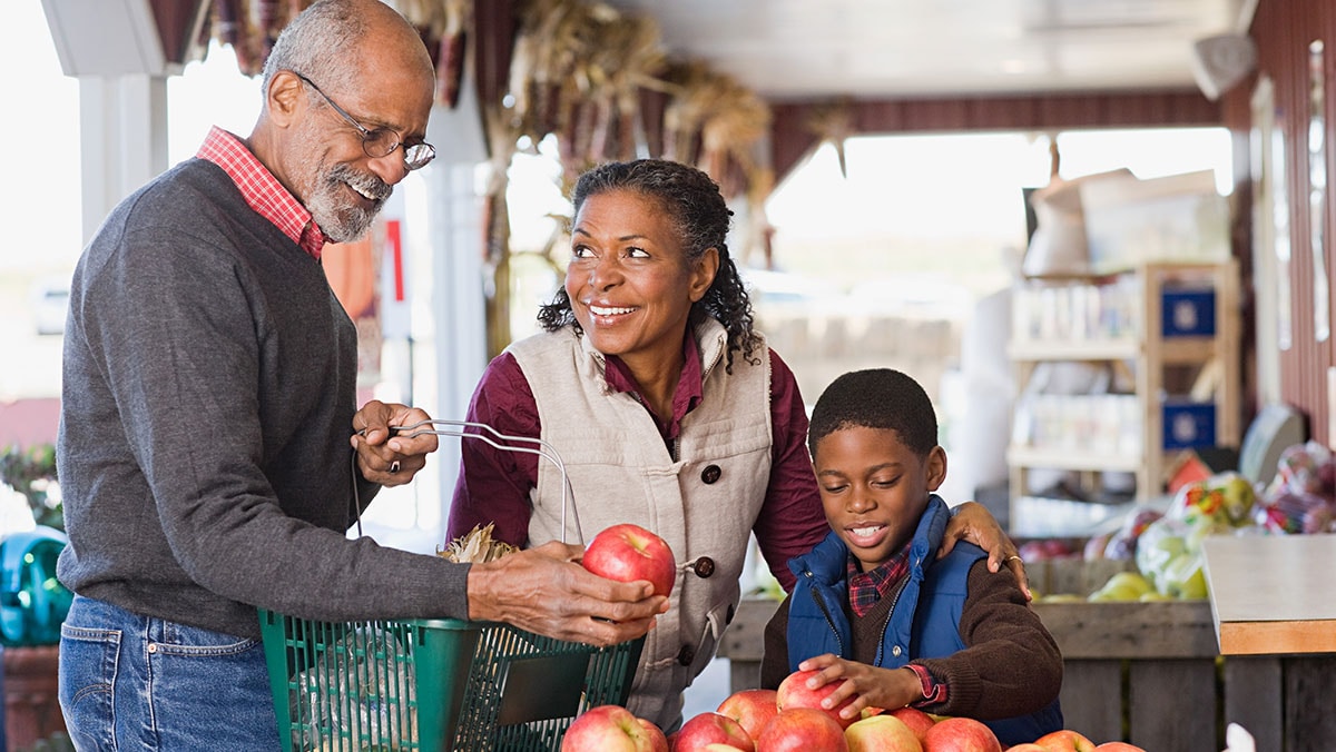 African American man and family shopping at a farmers market.