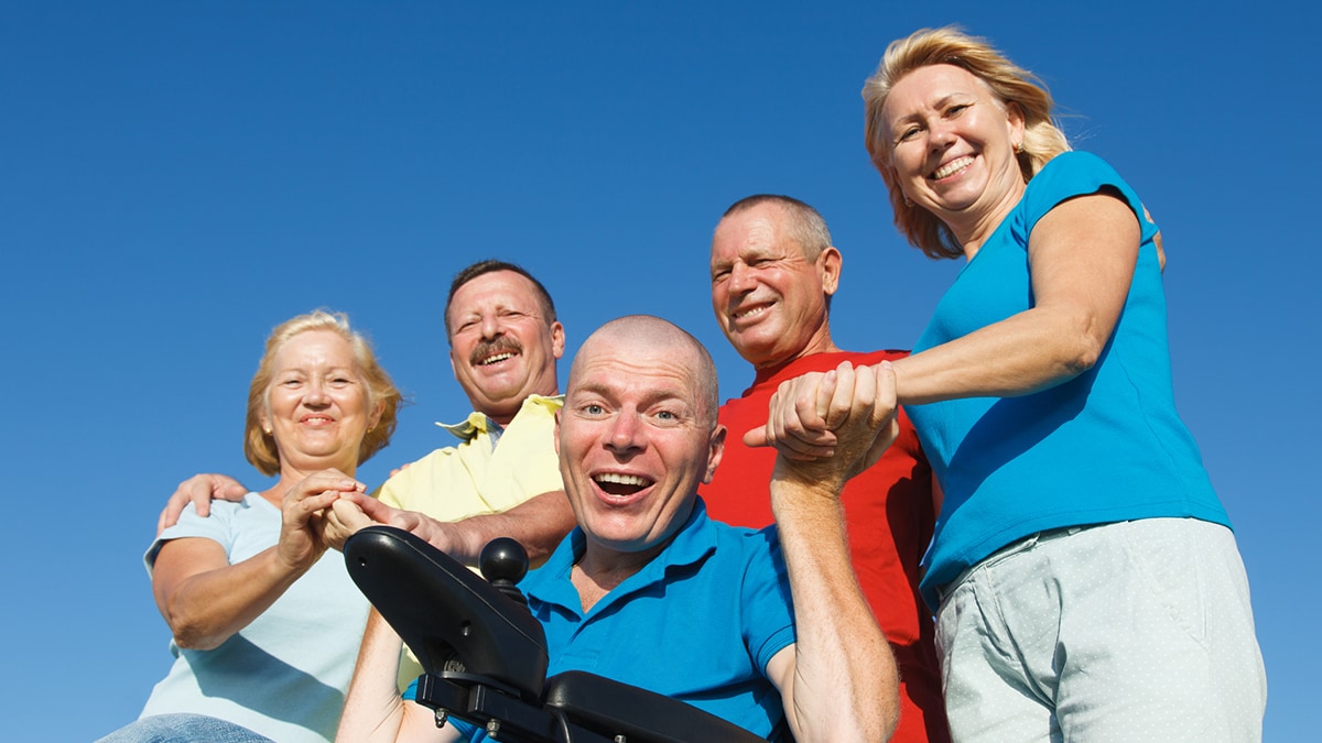 Man in wheelchair with family outside