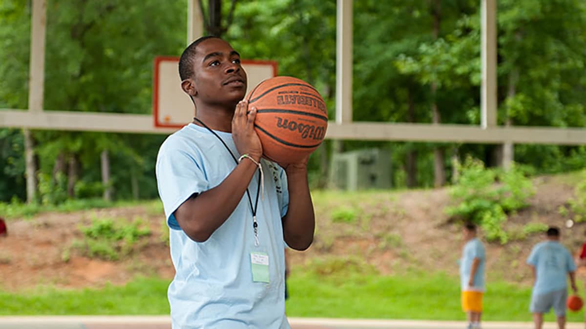 Boy shooting basketball at a park