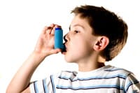 Young boy using an emergency inhaler.