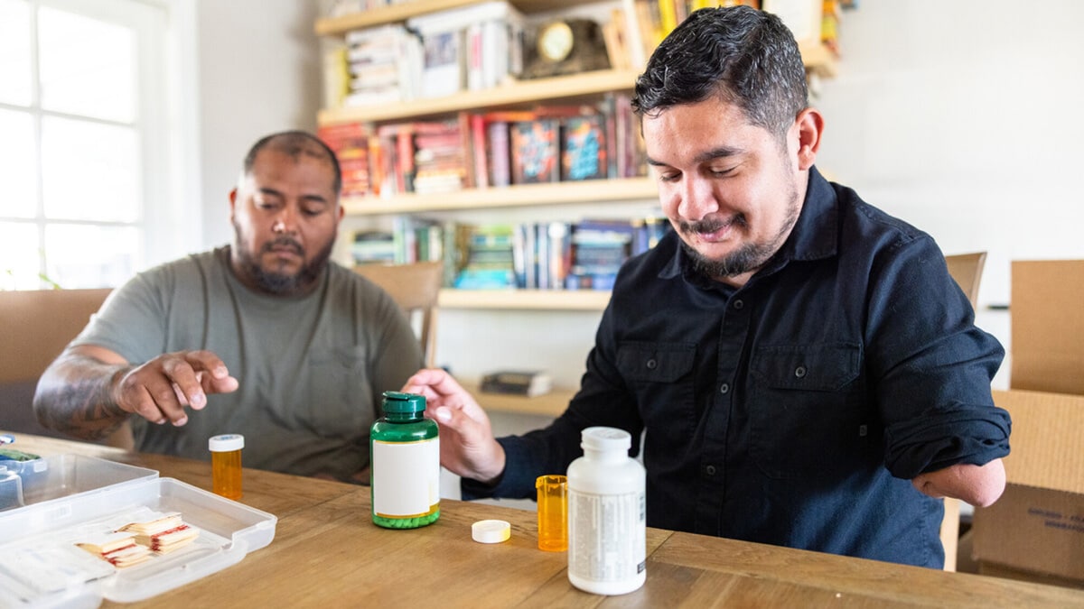 Two veteran disabled hispanic housemates packing a disaster response kit