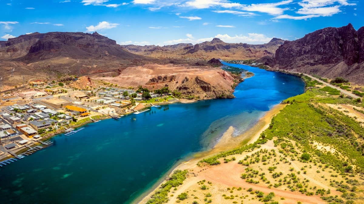 River flowing through desert mountains, with a small town on one shore