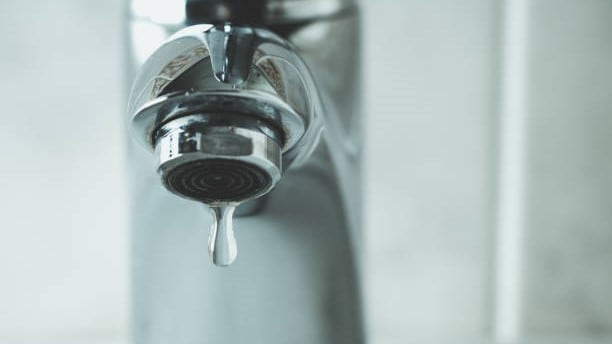 Water faucet with a drop of water coming out