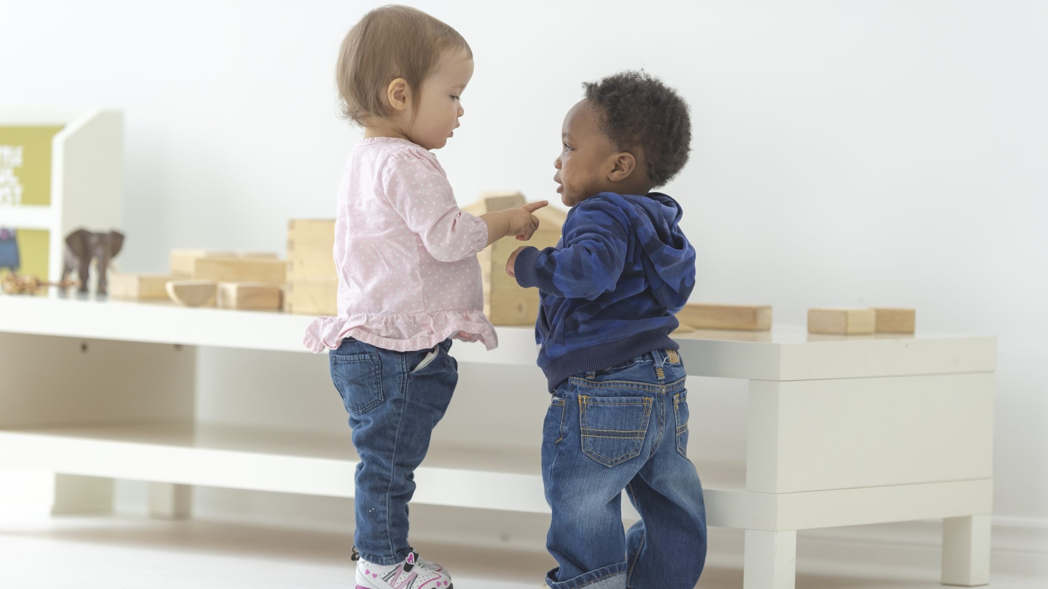 Two toddlers talking in an early care and education classroom.