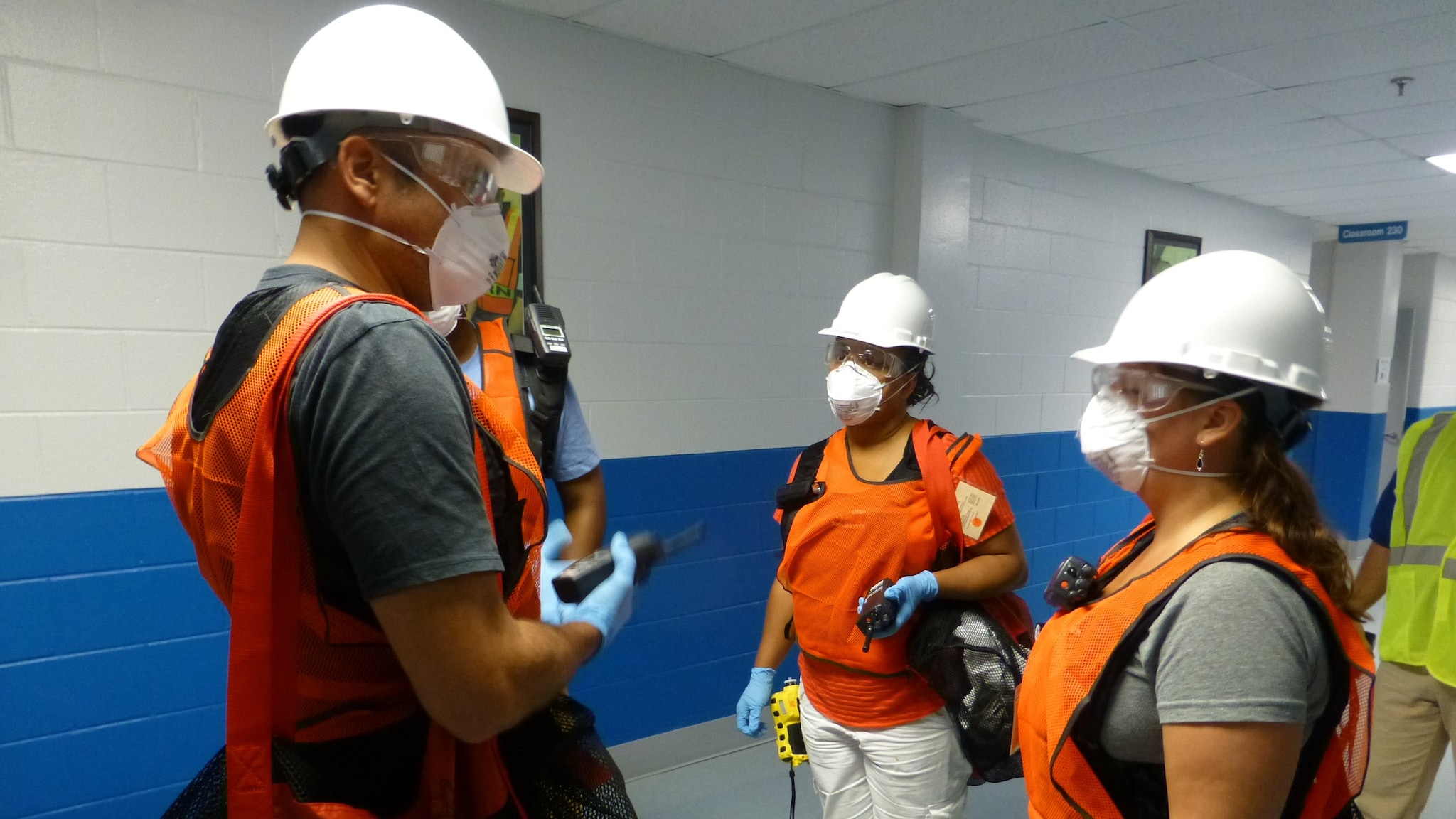 A group of people in hard hats and neon vests inside a building.