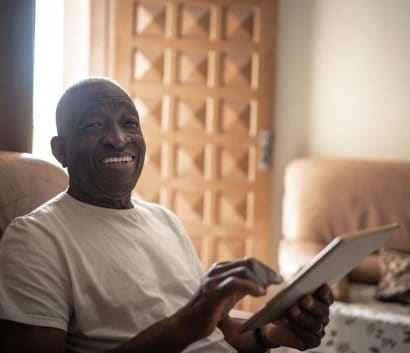 Portrait of senior man using digital tablet at home