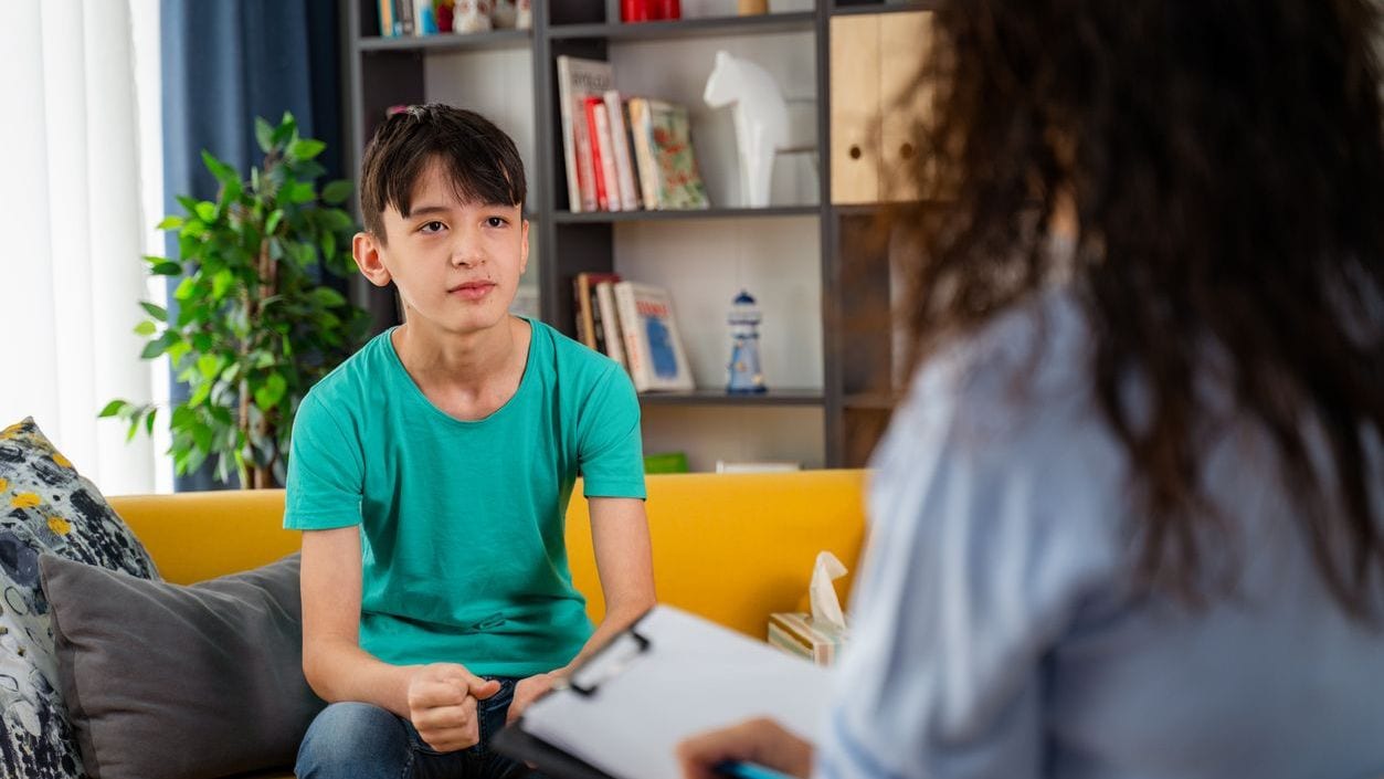 A psychologist counseling a teenage child in an office
