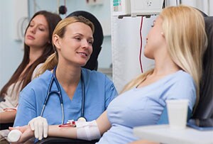 Nurse comforting patient during blood donation