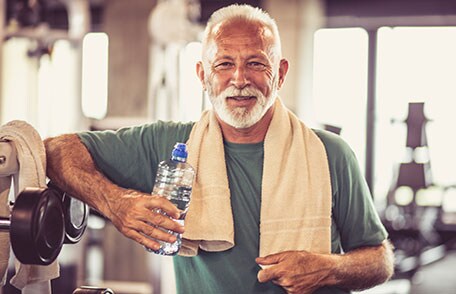 Man in gym holding water bottle
