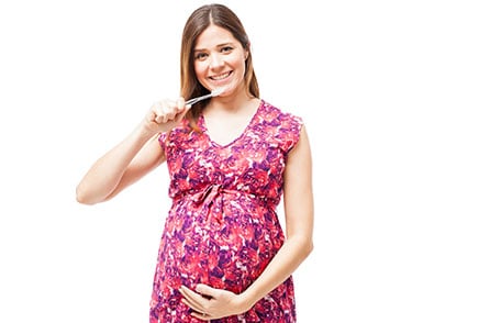 Pregnant woman brushing teeth