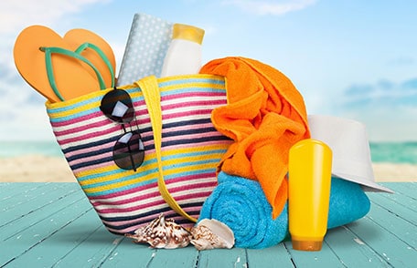 Beach bag with towels, sunscreen, sunglasses and flip flops