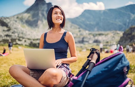 Woman using laptop in scenic mountain area