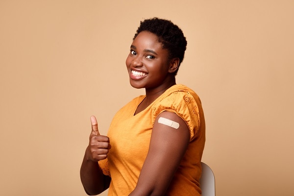 Smiling Black Woman Showing Vaccinated Arm And Thumbs-Up, Be...
