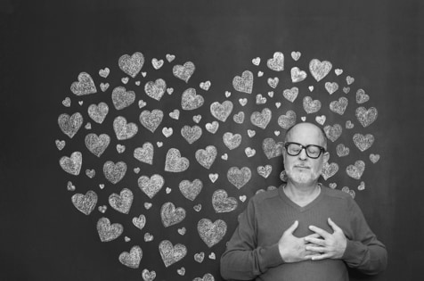 Man in front of hearts on wall