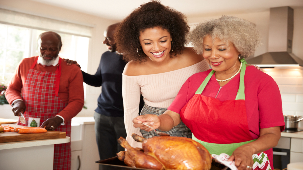 Family gathered in kitchen preparing holiday turkey