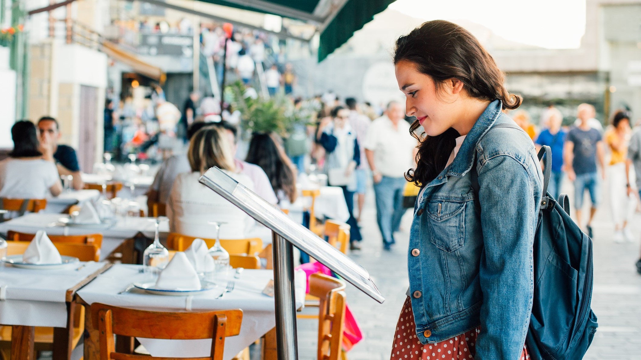 Woman standing outside reading a restaurant menu