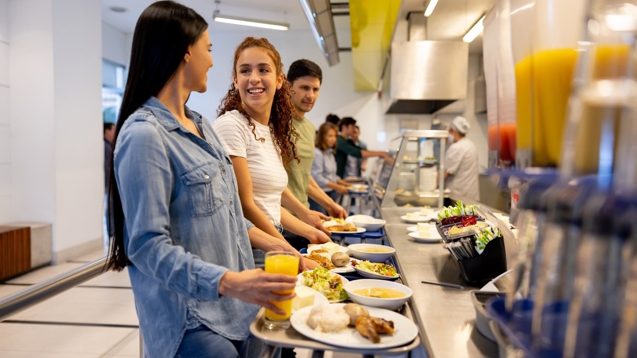 University-aged students going through cafeteria serving line.