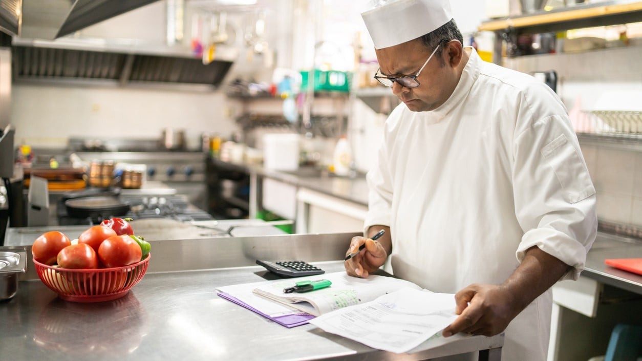 Chef with papers in commercial kitchen